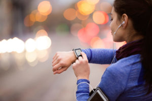 Young woman wearing a smart watch while jogging. Wearable devices such as smart watches could help revolutionise how clinicians treat and track mental health issues. Photo: iStock.
