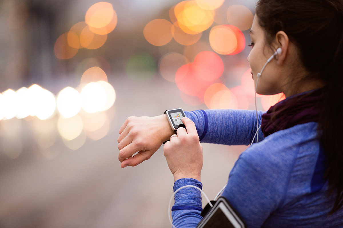 Young woman wearing a smart watch while jogging. Wearable devices such as smart watches could help revolutionise how clinicians treat and track mental health issues. Photo: iStock.
