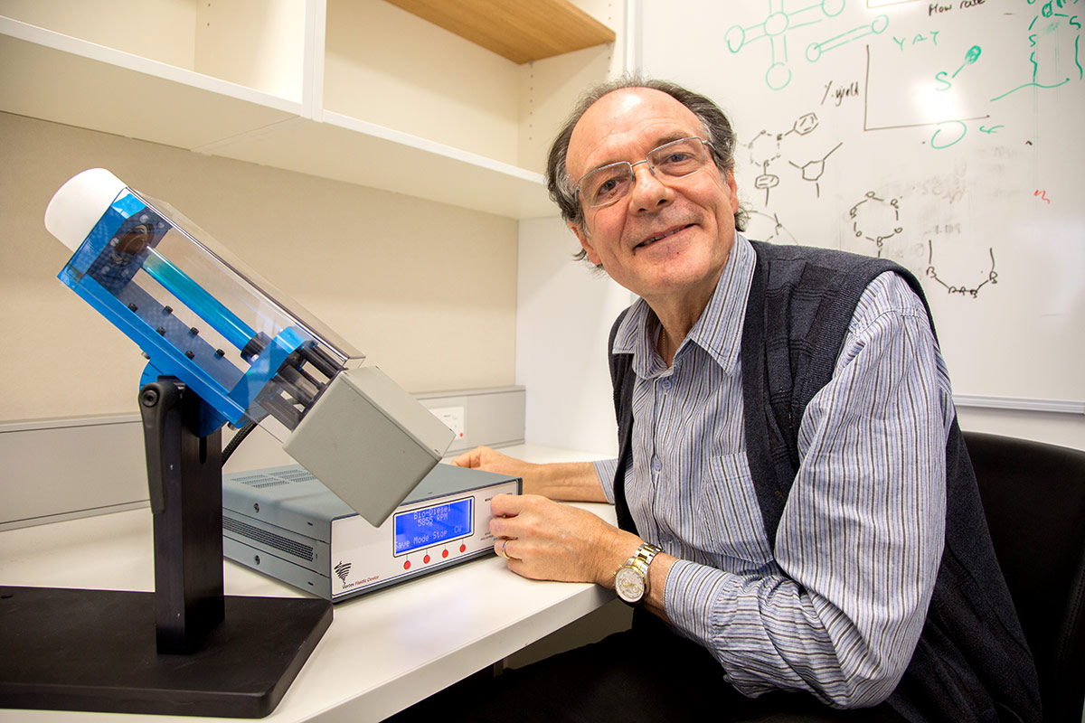 Professor Colin Raston with a laboratory prototype Vortex Fluidic Device.
